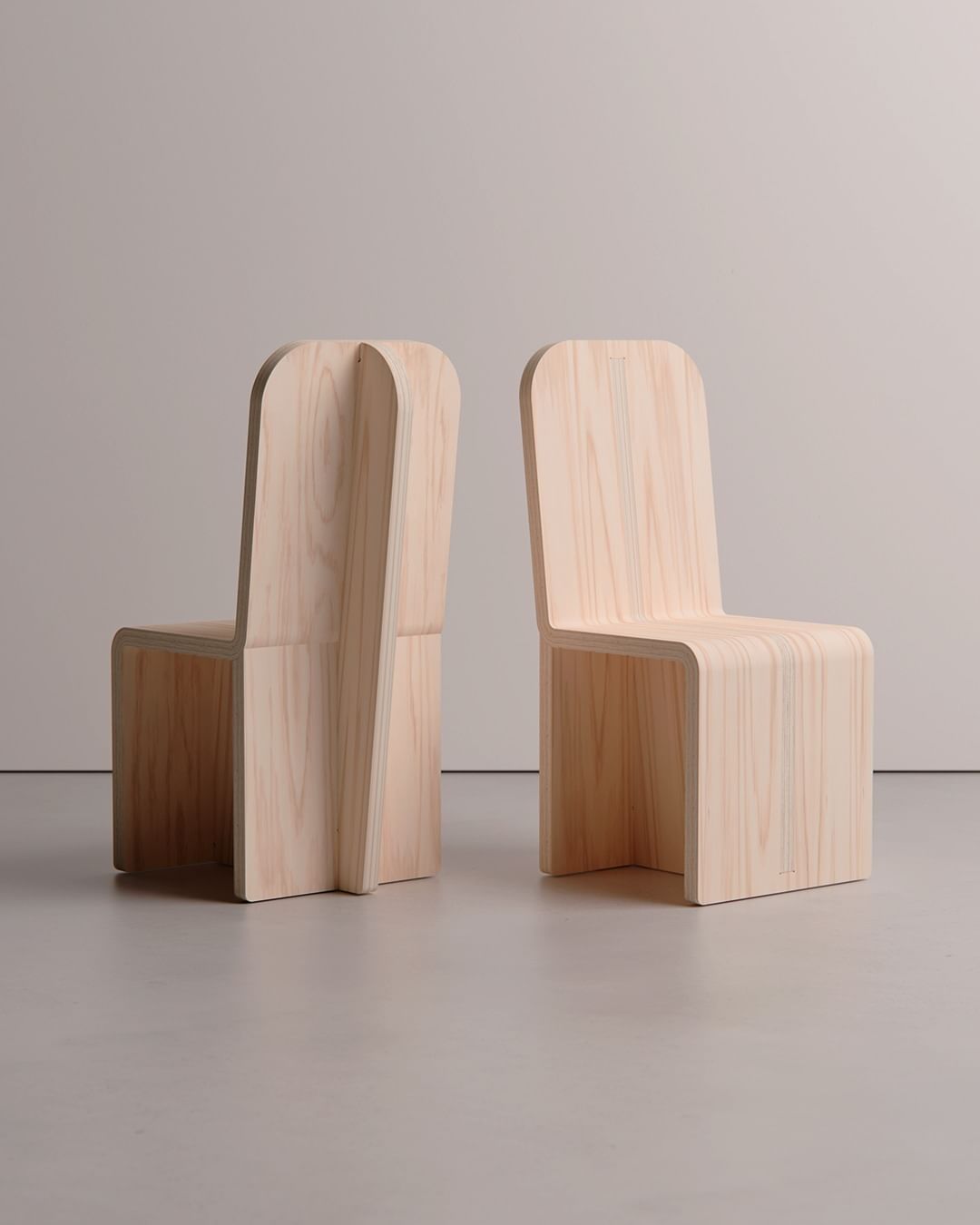 A set of two unique wooden chairs with a minimalist design, showcasing creative craftsmanship