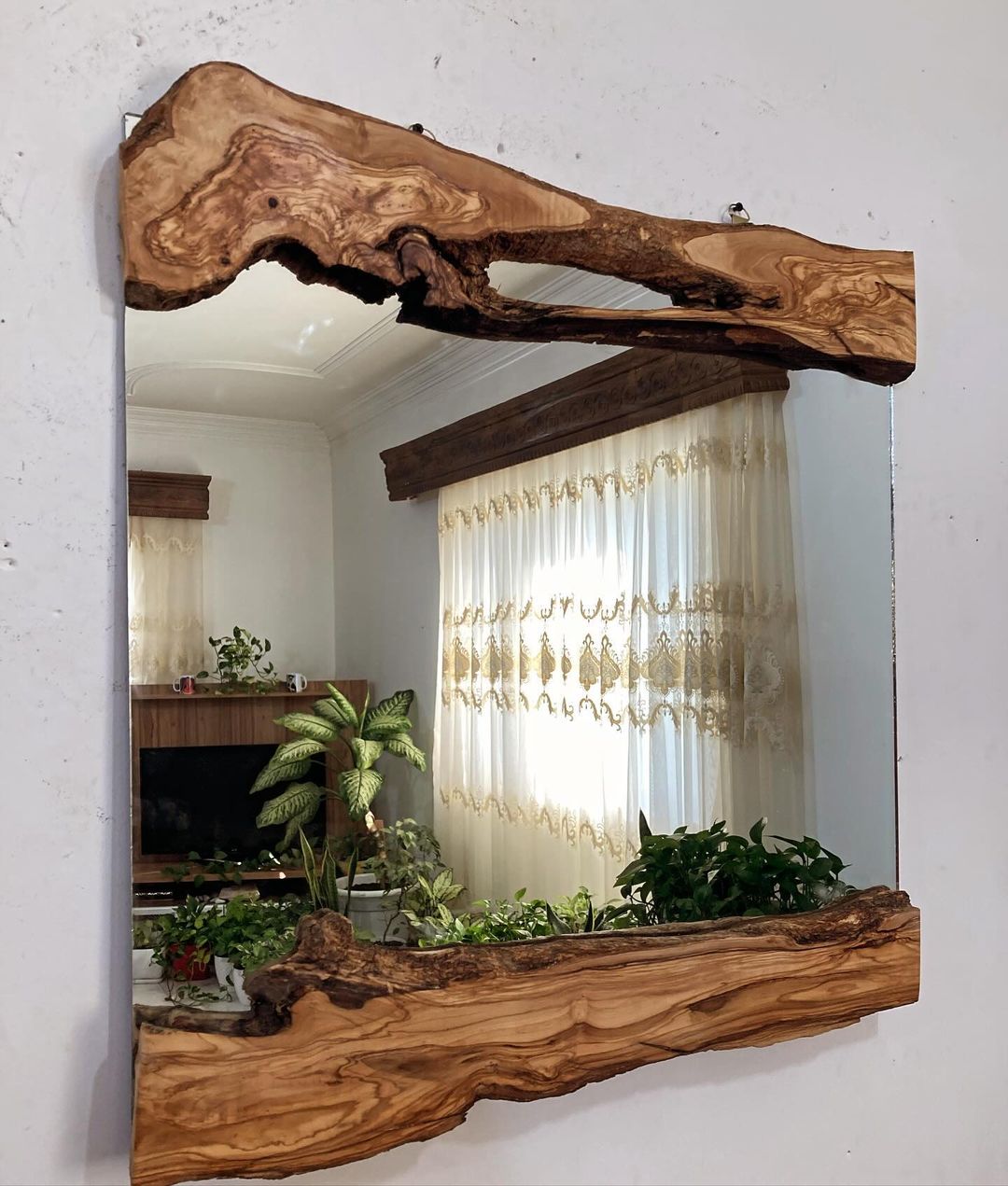 Unique wooden-framed mirror reflecting a room