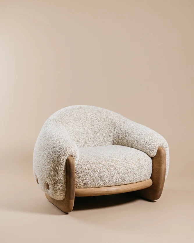 A modern cozy armchair with textured fabric upholstery and wooden frame