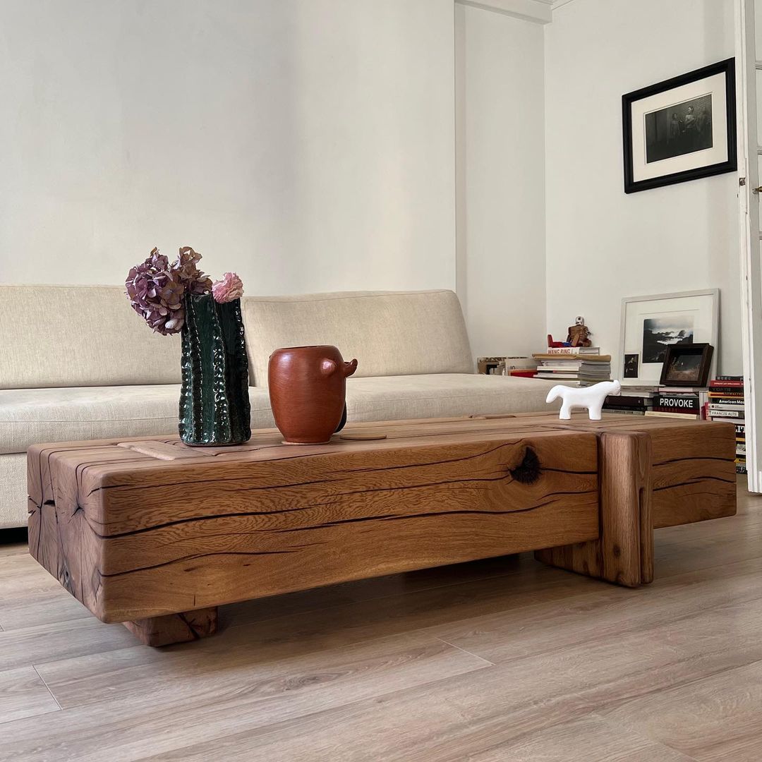 A minimalist living room with a large solid wood coffee table