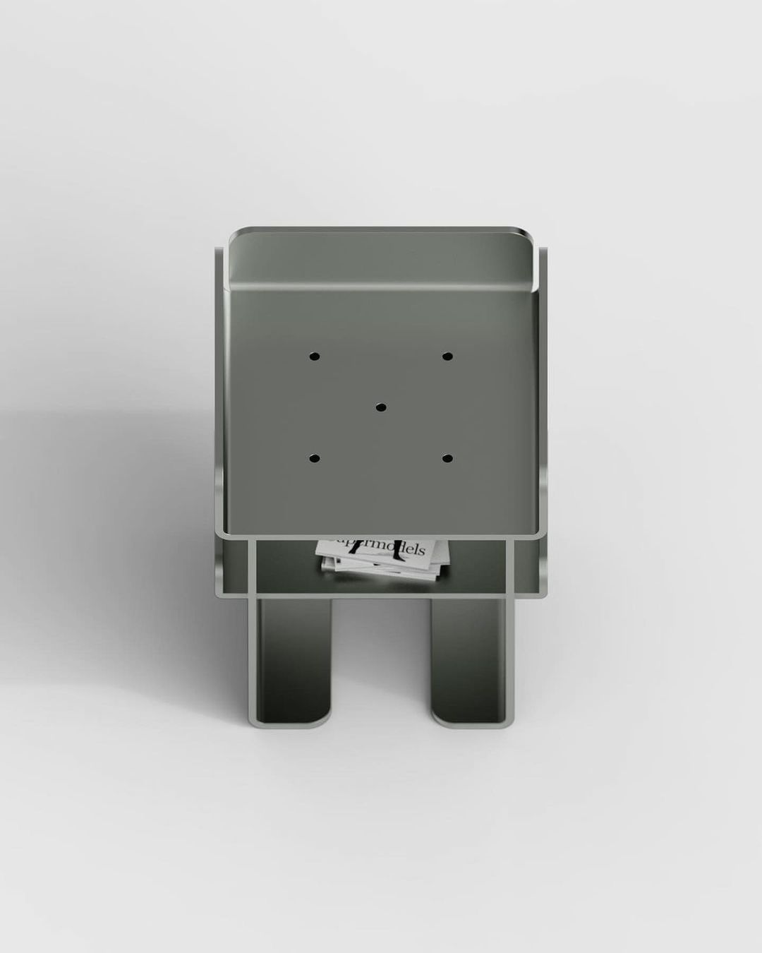 A minimalist grey metal side table with a unique slot for magazines