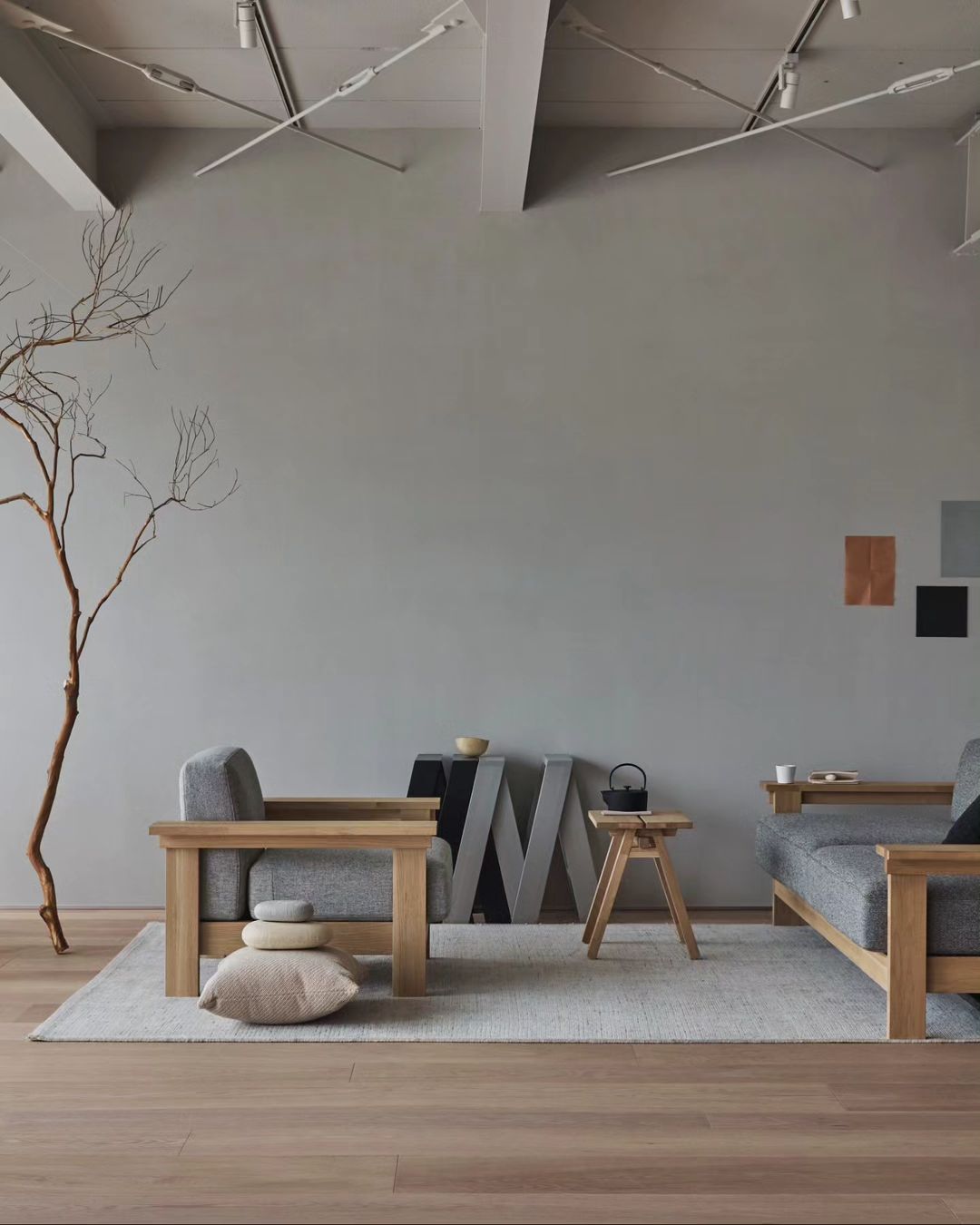 A modern minimalist living room with harmonious wooden furniture and subtle grey textures