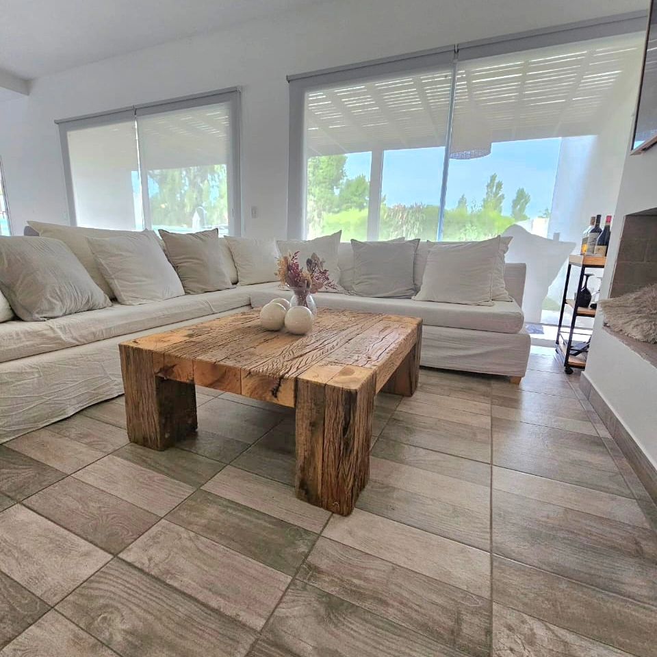 A minimalist living room with a large plush sofa and a rustic wooden coffee table