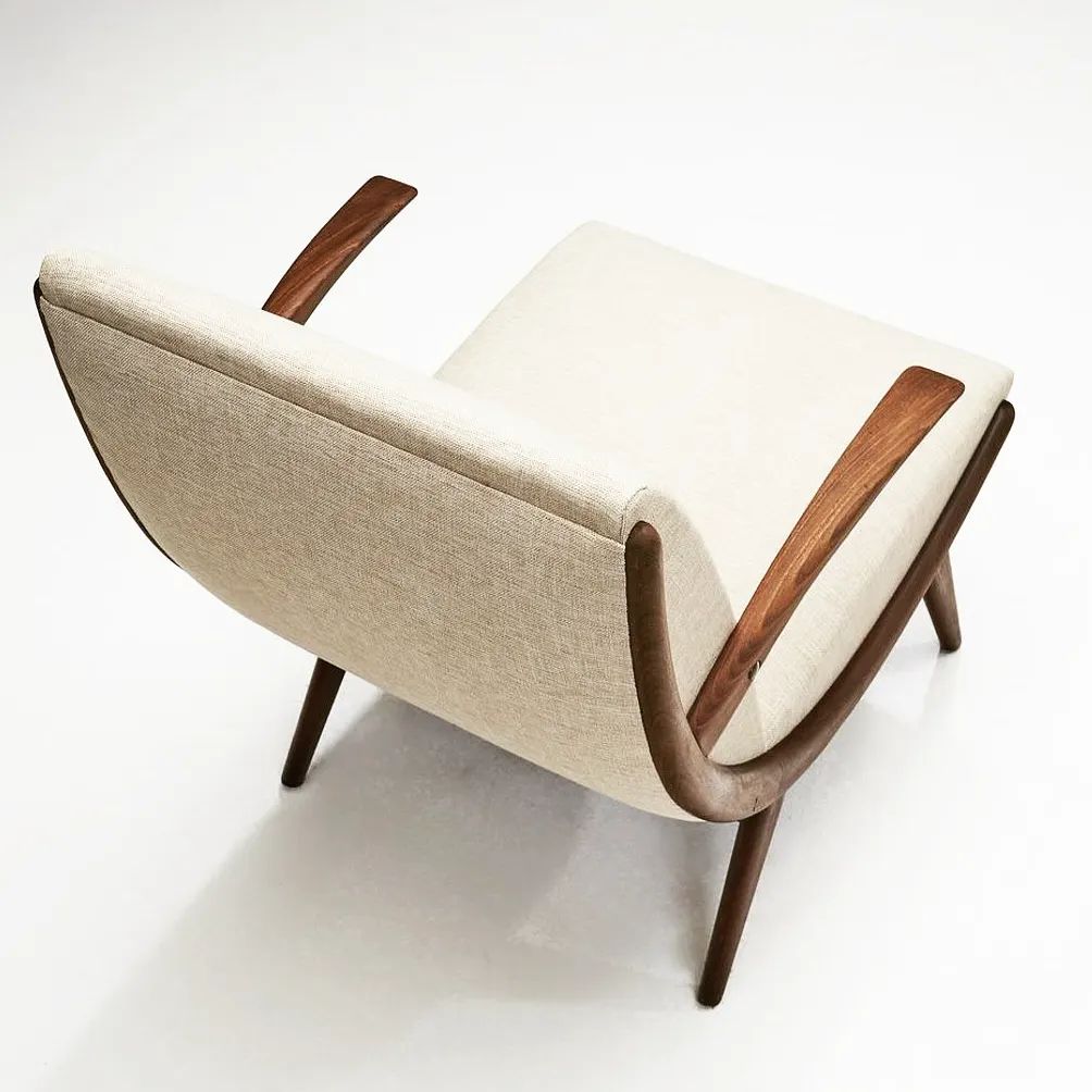 A modern style armchair with a beige upholstery and smooth wooden armrests