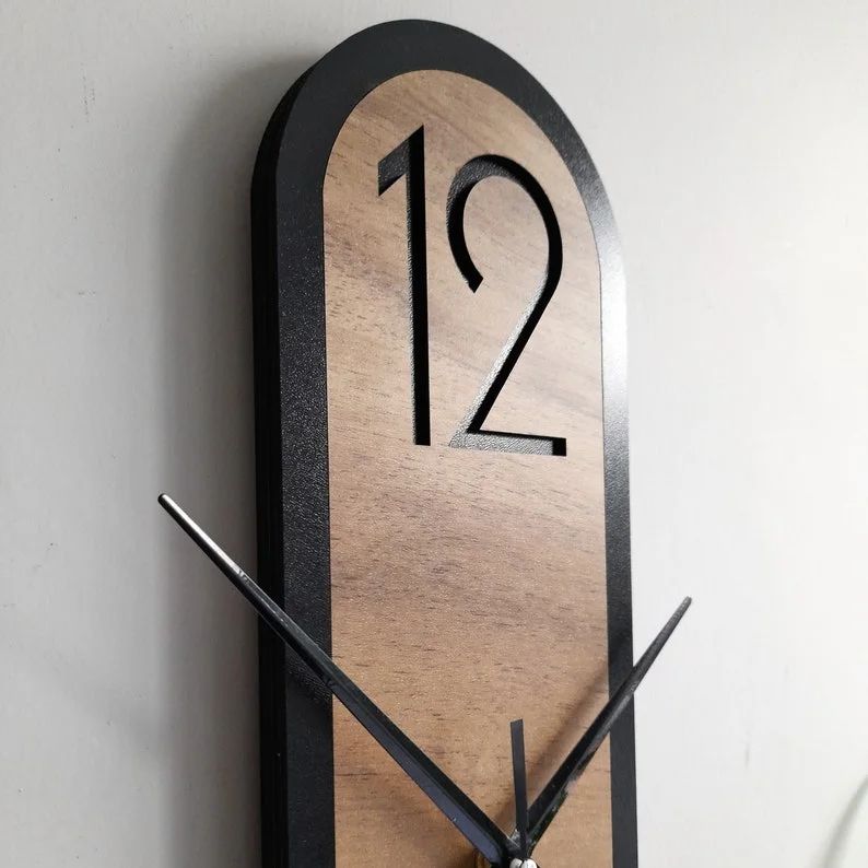 A modern wall clock showcasing large numbers and a wooden backdrop