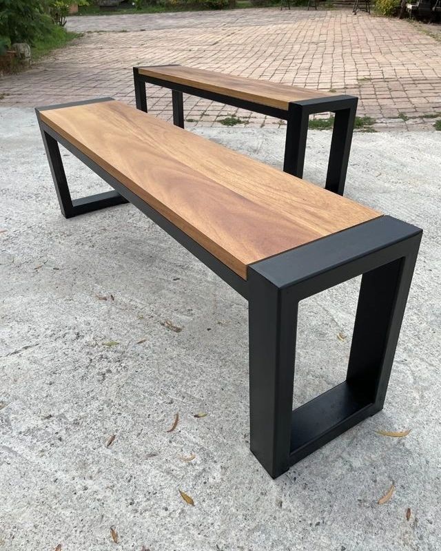 A modern wooden and metal bench with a sleek design