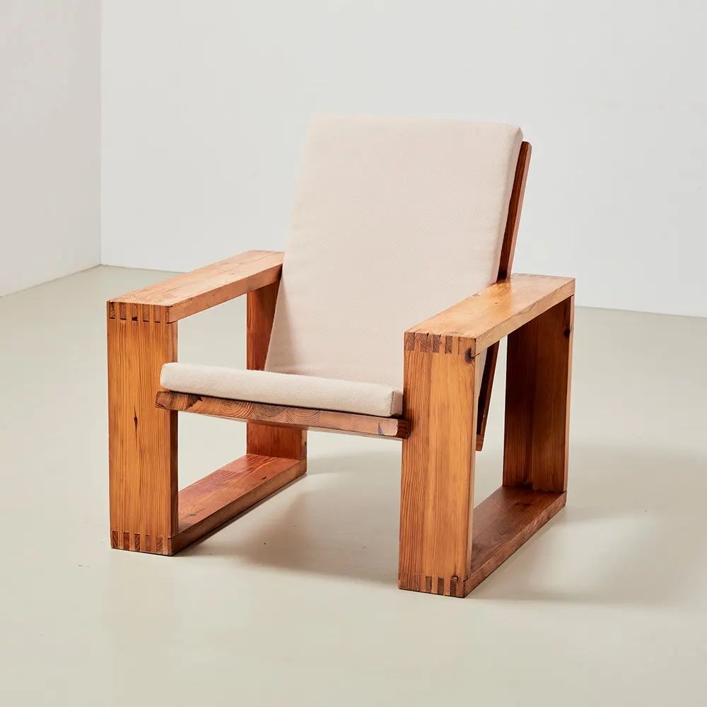 A minimalist wooden chair with a simple fabric backrest and seat cushion