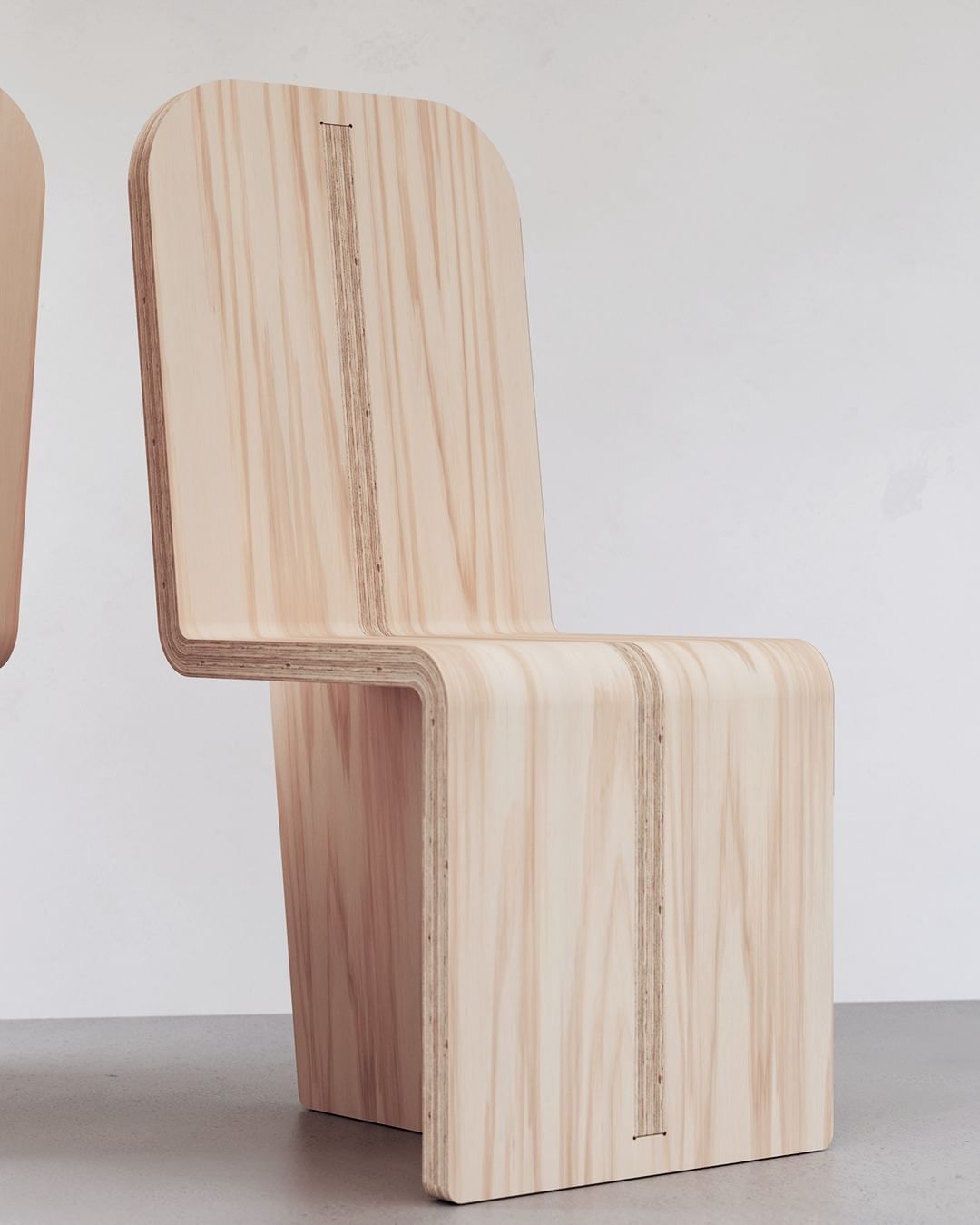 A minimalist wooden chair with a unique vertical slit in the backrest