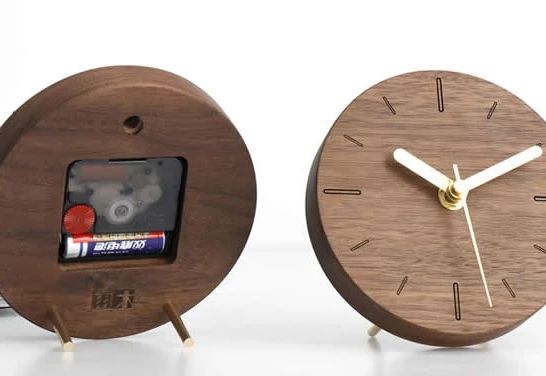 A modern wooden clock on the left with a visible mechanical tape cassette player and another minimalistic wooden clock on the right with gold-colored hands