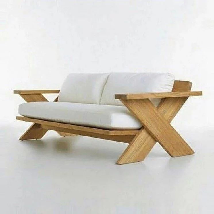 A modern wooden lounge chair with a plush white cushion