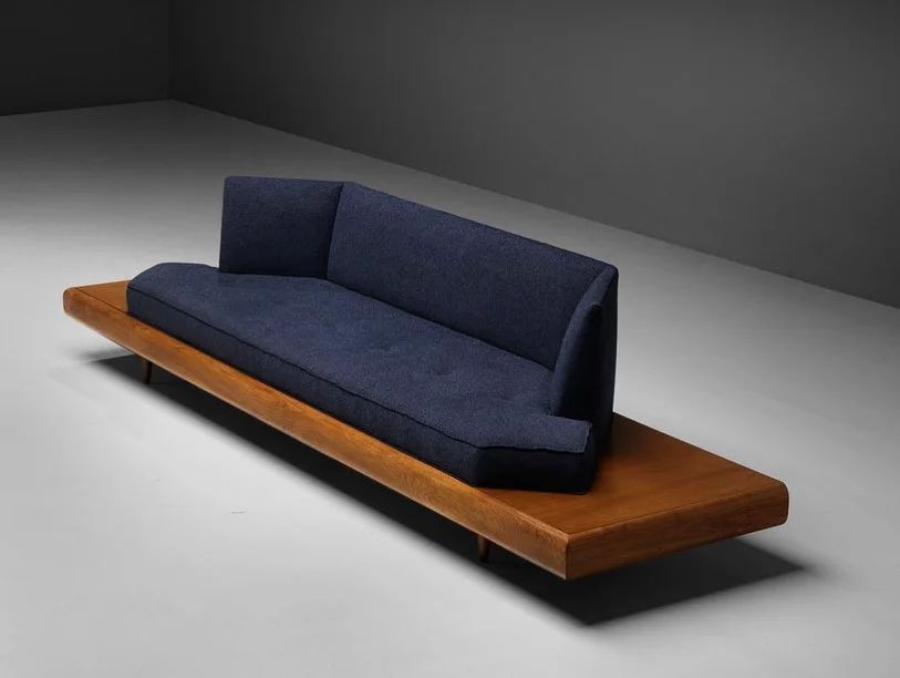 A minimalist wooden sofa with plush navy blue cushions