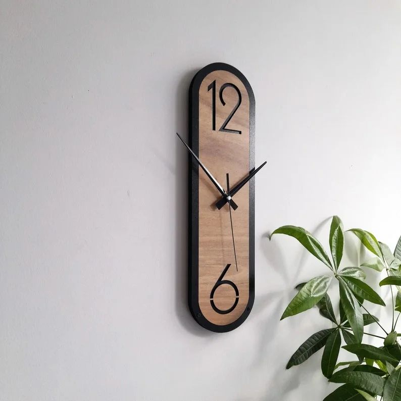 A modern wooden wall clock with black framing and large numbers