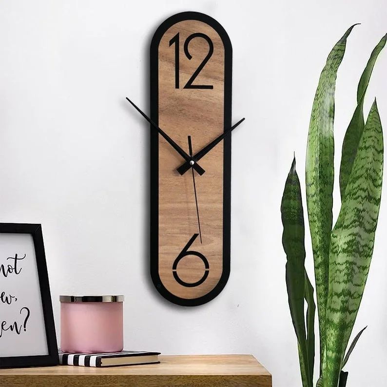 A minimalist wooden wall clock with a uniquely elongated oval shape