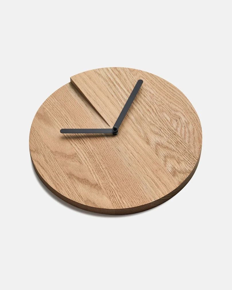 A modern wooden wall clock with unique triangular hour markings.