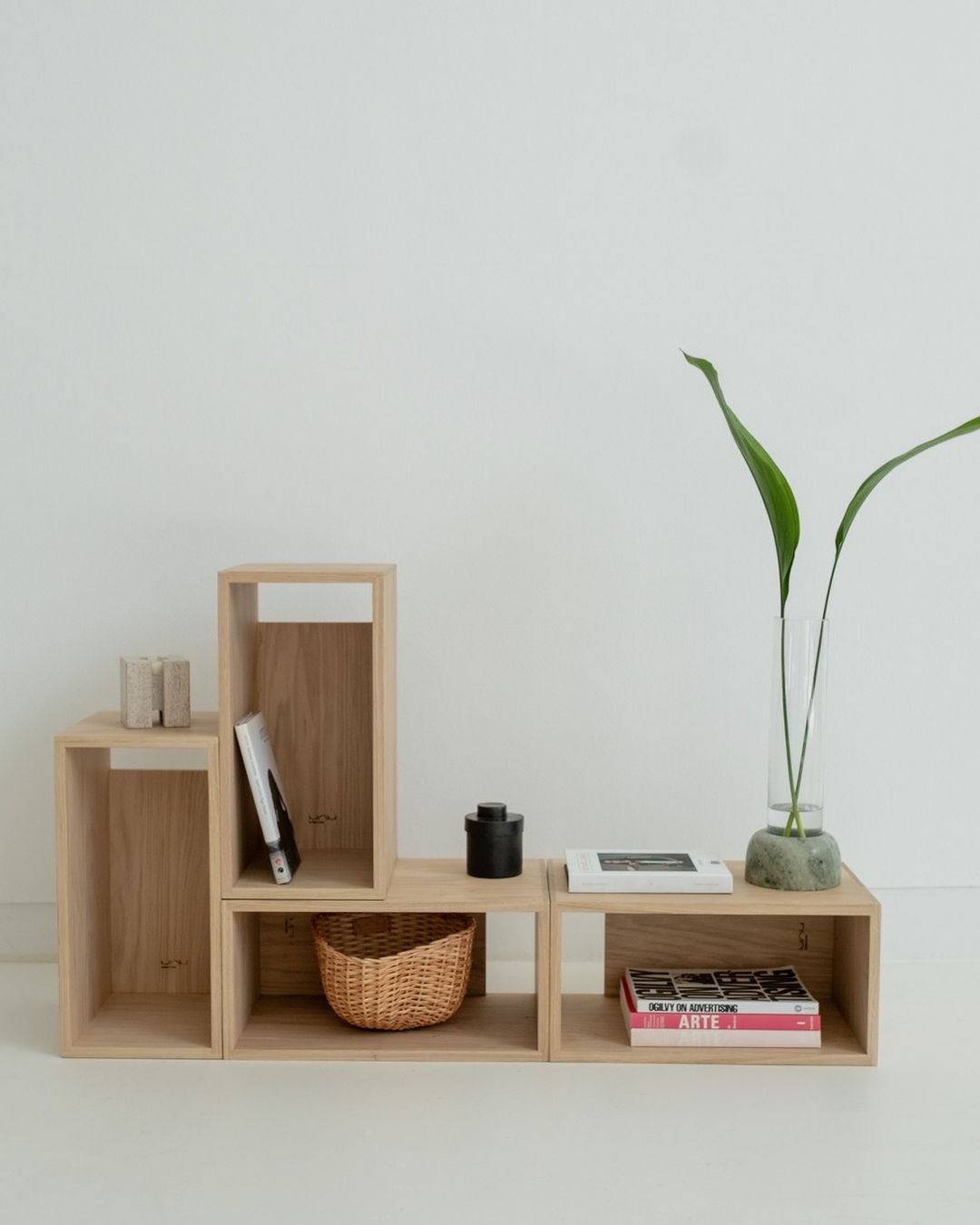 Minimalist wooden shelving units with various decorative and functional items