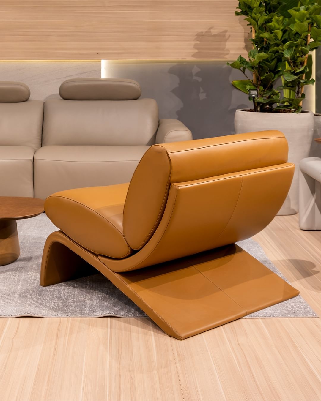 A modern and chic living room features a bold mustard leather lounge chair