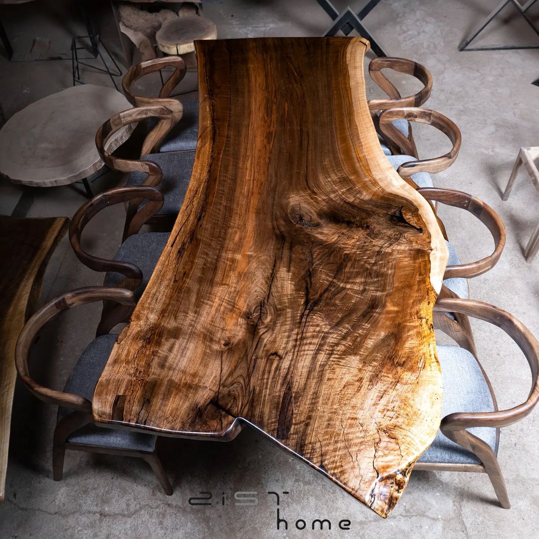 A natural edge wooden table with matching curved chairs