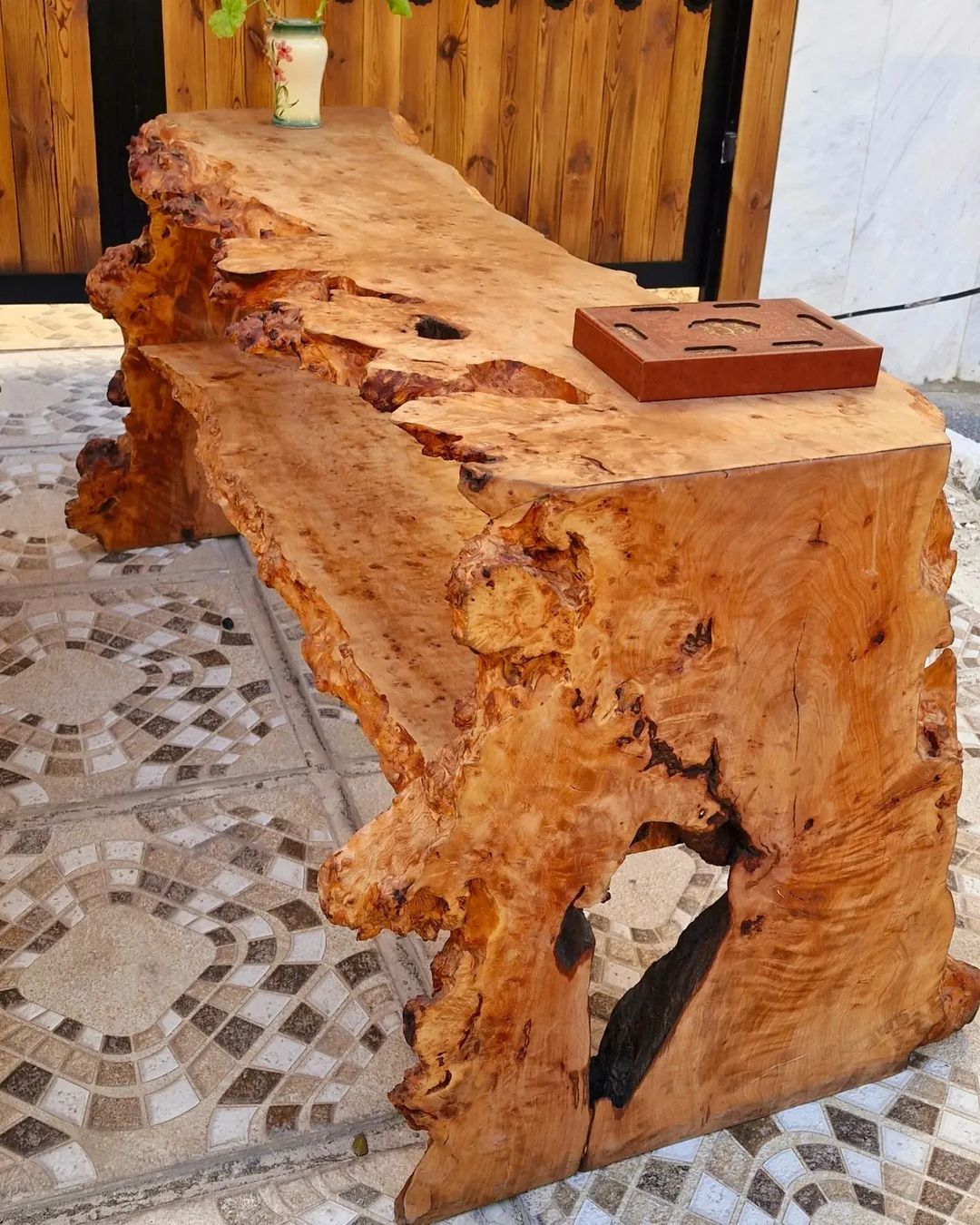 A uniquely crafted natural edge wooden table with rich textures and organic holes