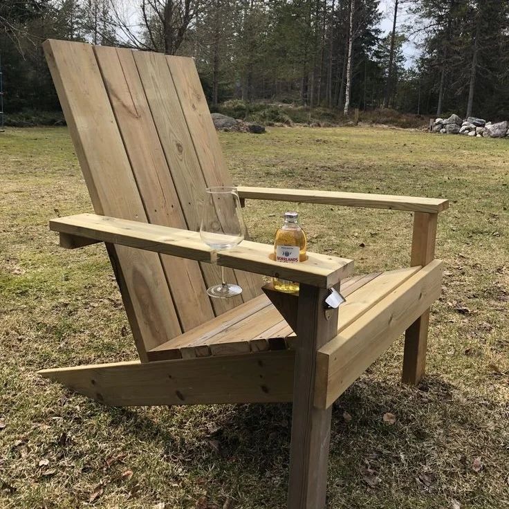 A cozy outdoor wooden chair with a built-in beverage holder