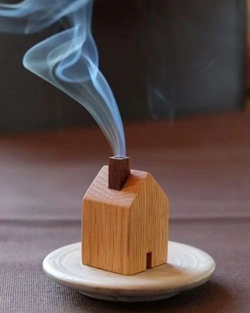 A quaint wooden incense house with smoke billowing from its chimney