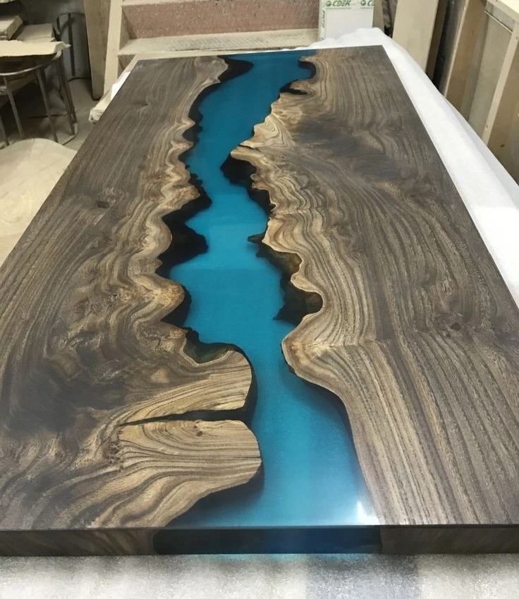 A stunning combination of natural wood and vibrant blue resin resembling a flowing river