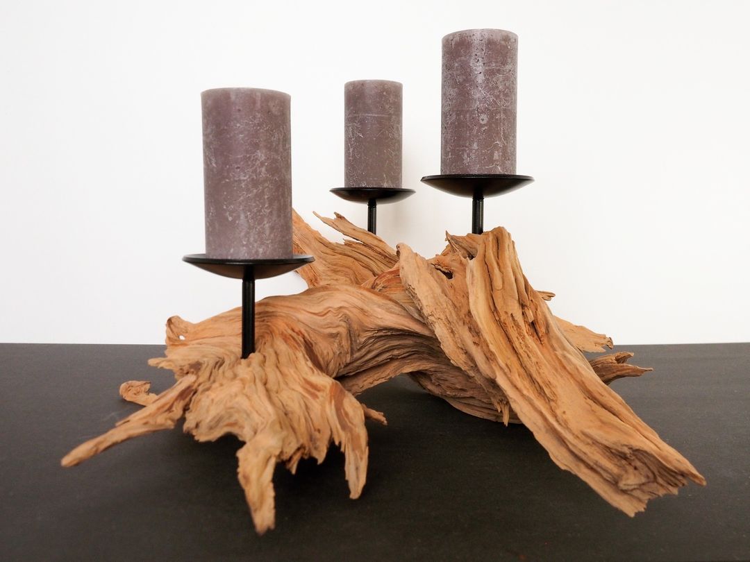 A unique candle holder display featuring rustic wooden driftwood and muted grey candles