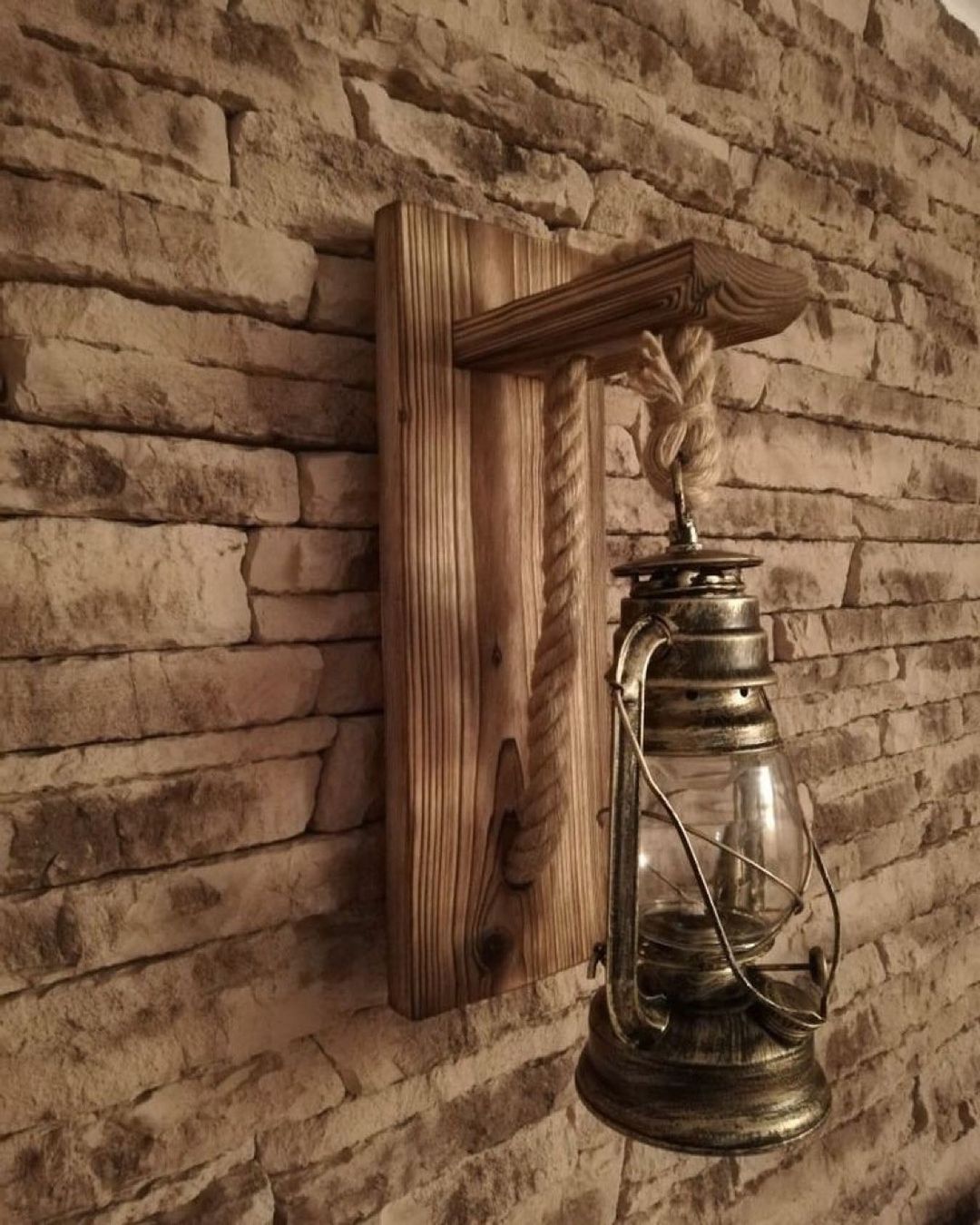 A rustic old-fashioned lantern hanging on a textured brick wall