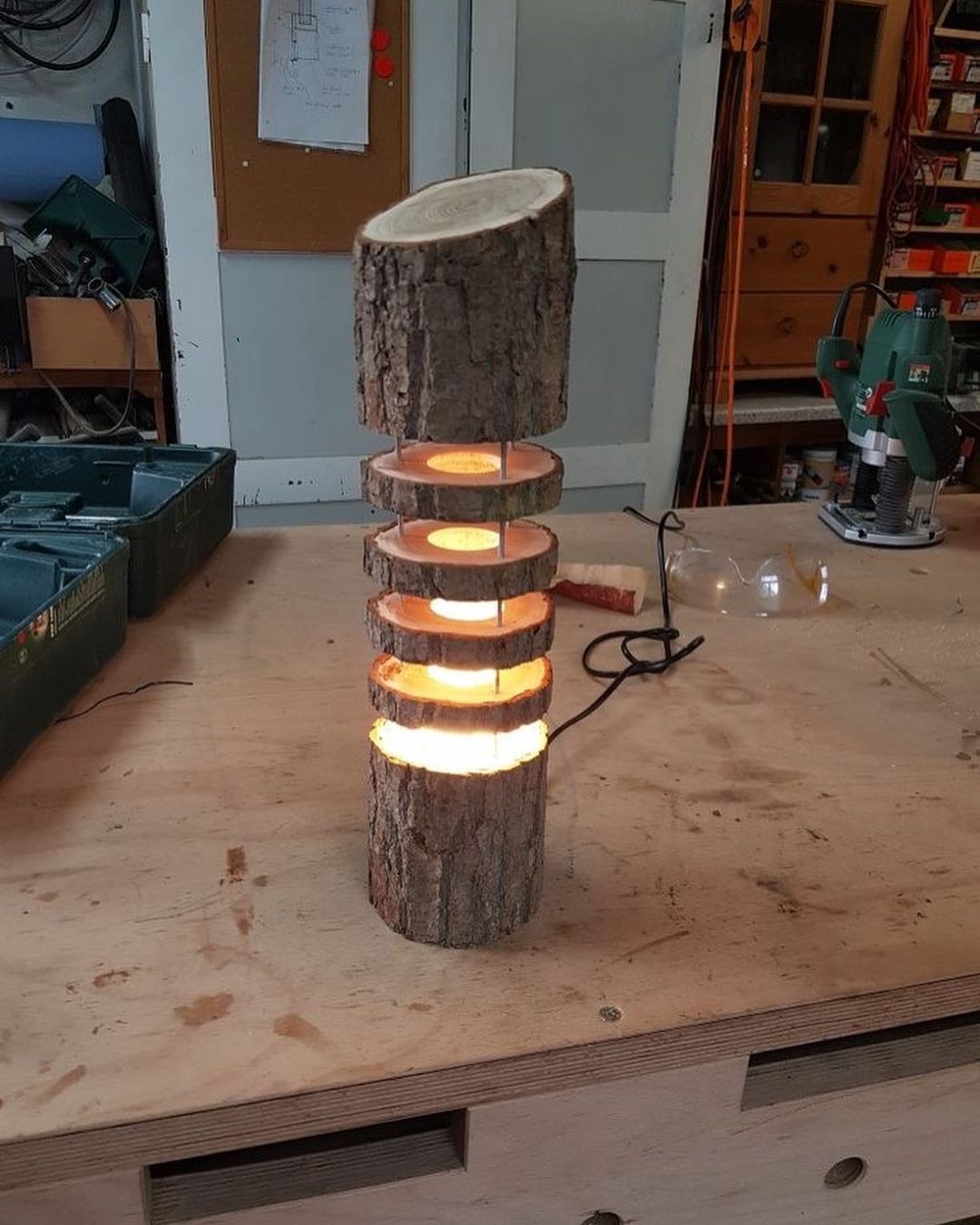 A rustic log transformed into a unique lamp with glowing rings