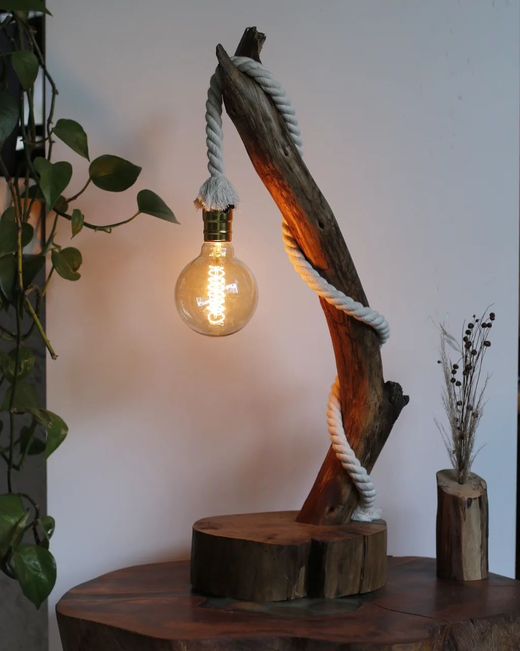 A uniquely crafted lamp combining natural wood and thick rope