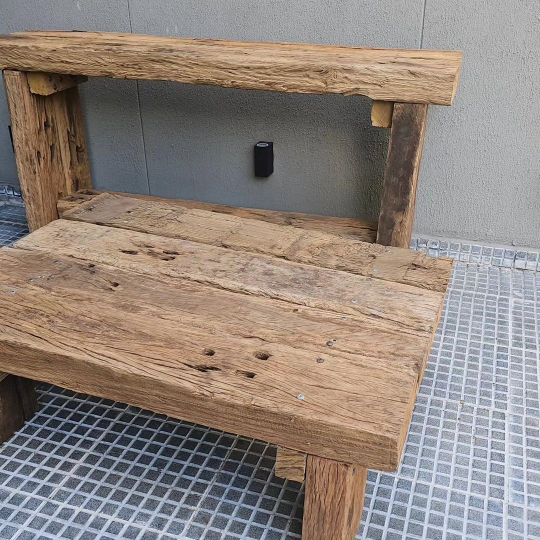 A rustic wooden bench featuring weathered textures and robust construction