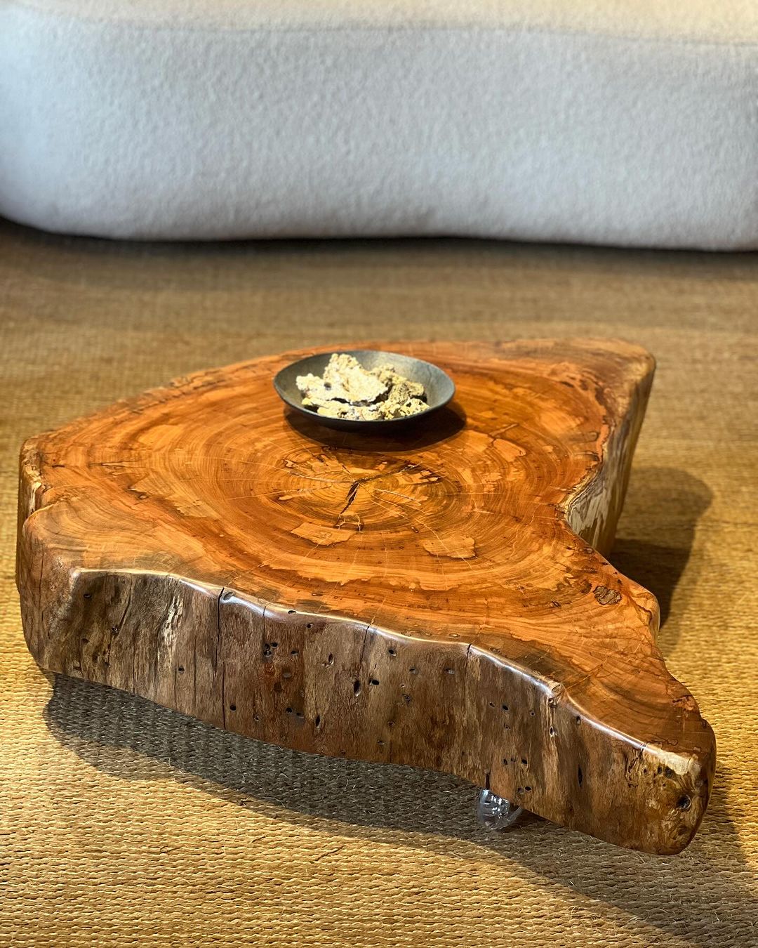 A rustic wooden coffee table with a unique organic shape and a smooth finish