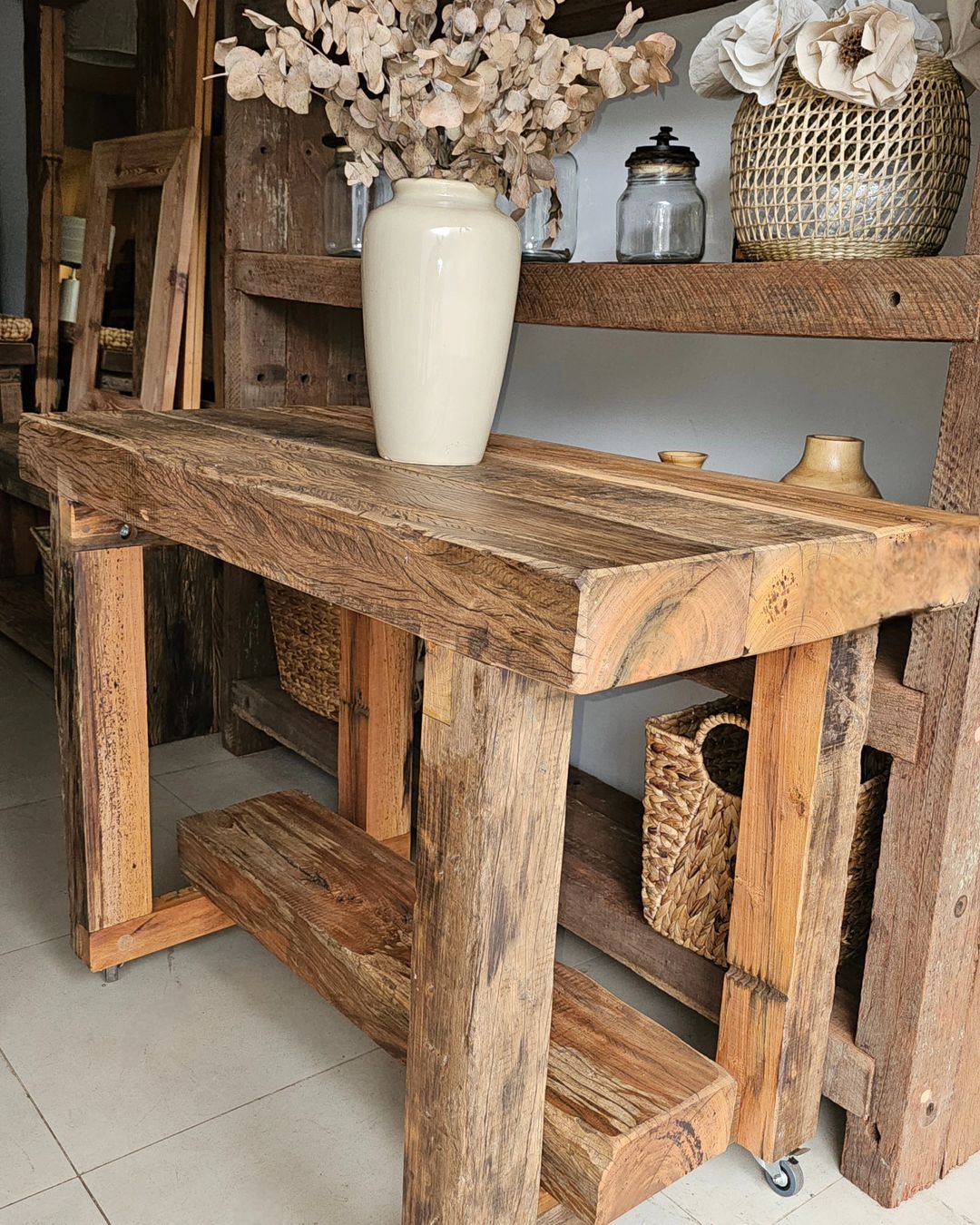 Rustic wooden console table with textured surface and vase