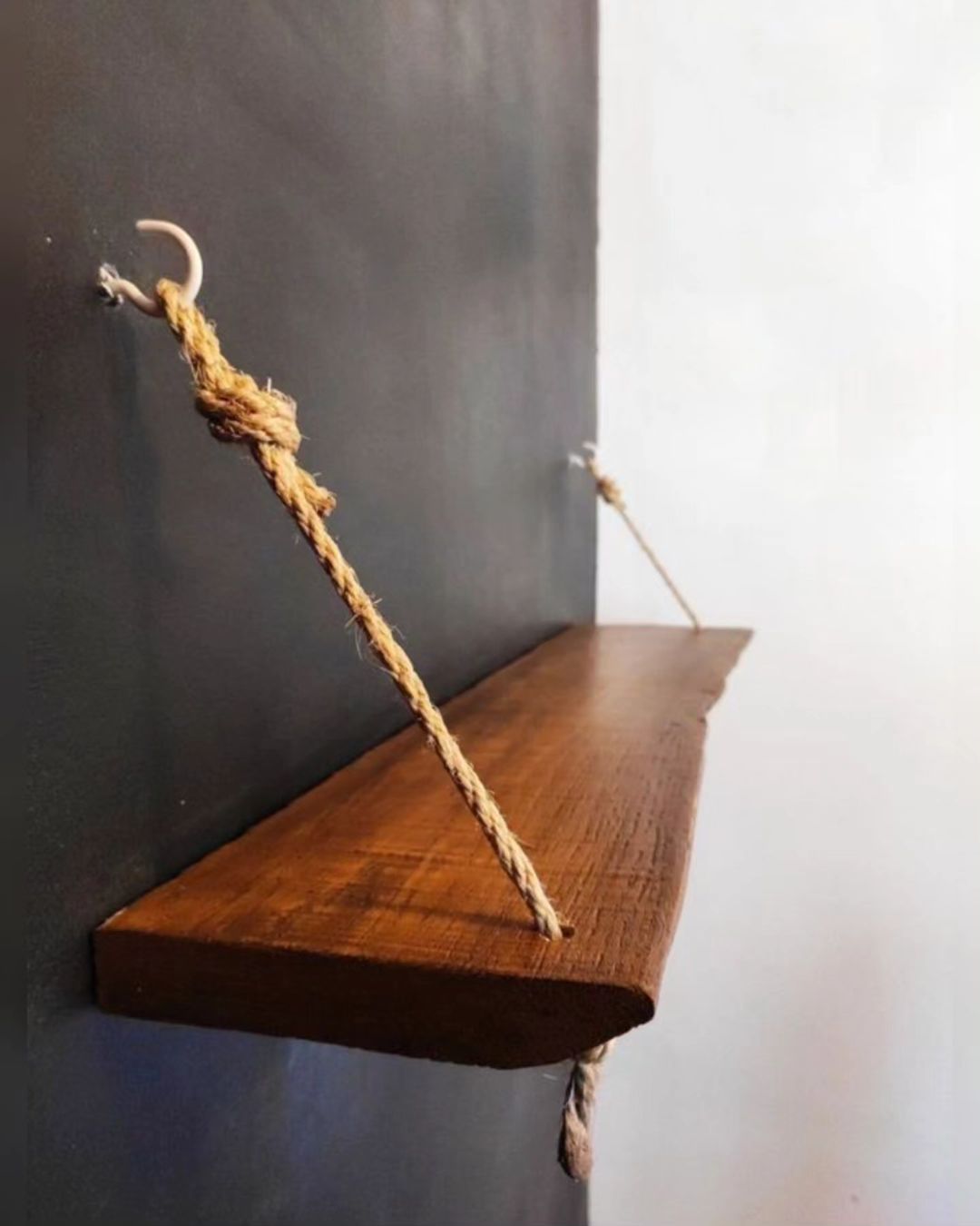 A wooden shelf suspended by ropes