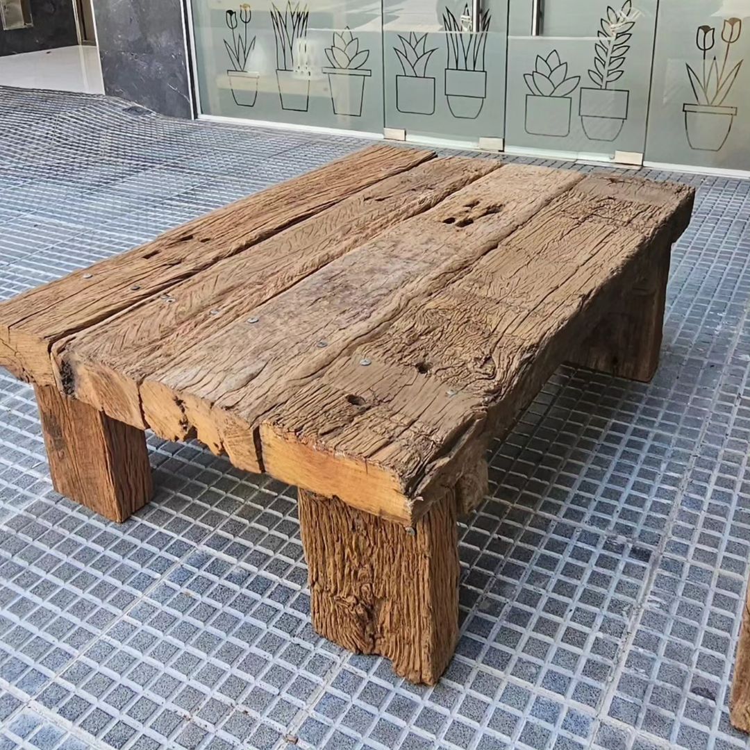 A robust, weathered wooden table with a distinctly rustic character