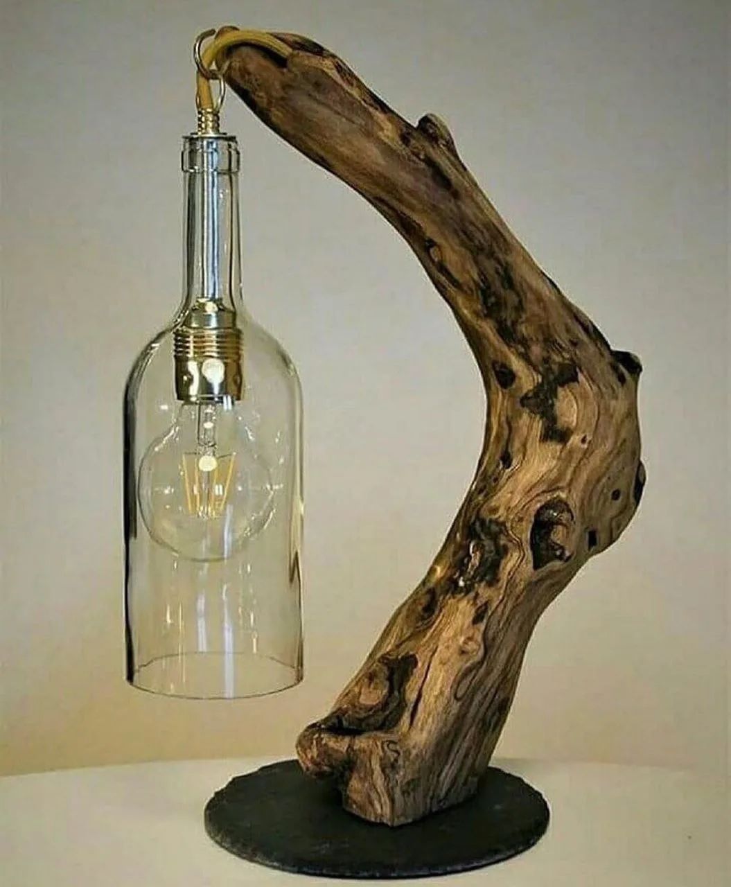 A creatively designed lamp with a driftwood base and a clear glass lampshade