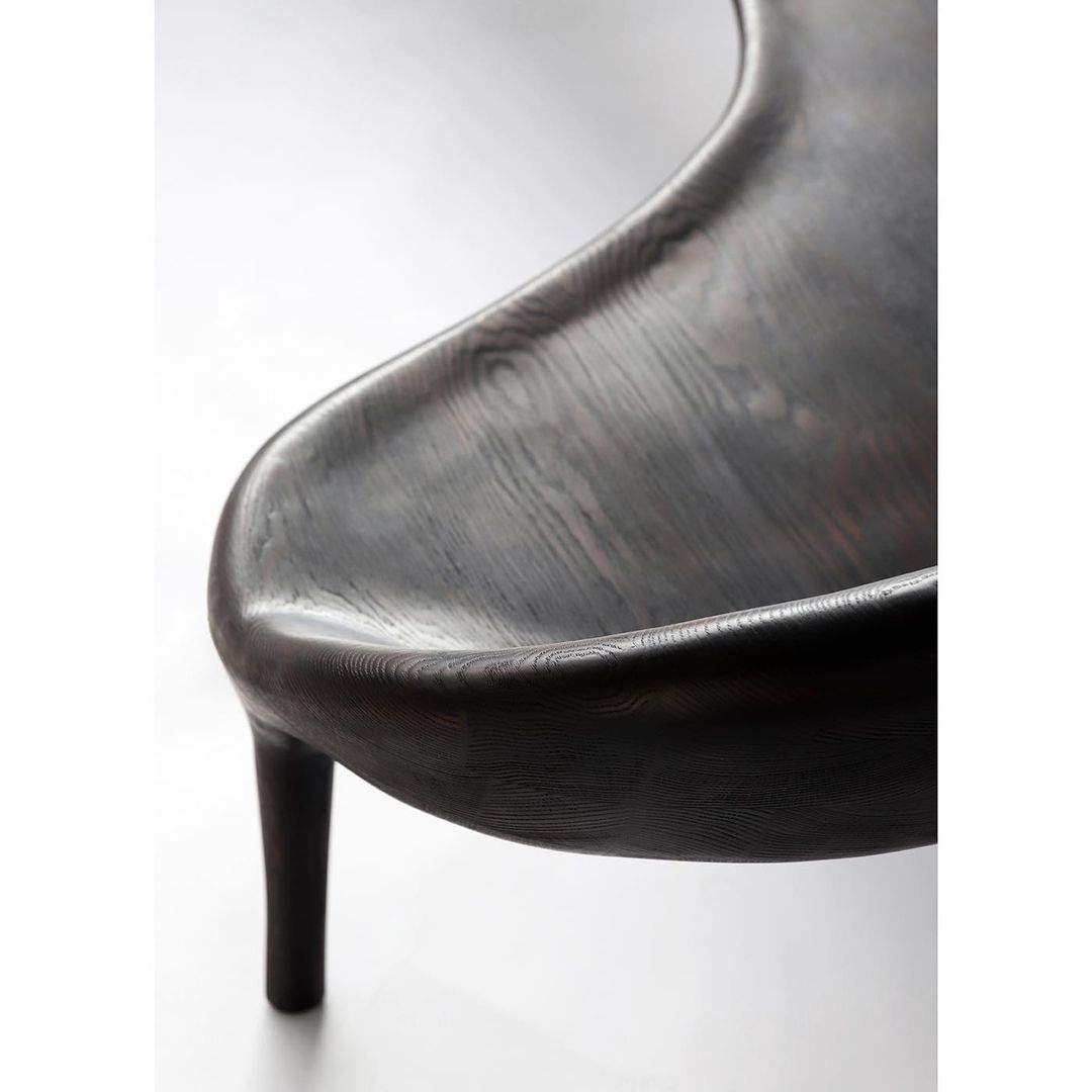 A sleek, sculptural modern chair with an emphasis on bold textures