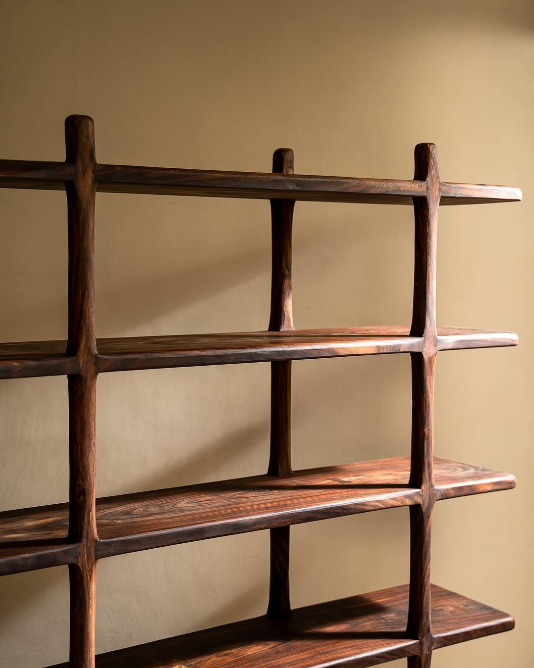 A sleek wooden bookshelf with unique joinery