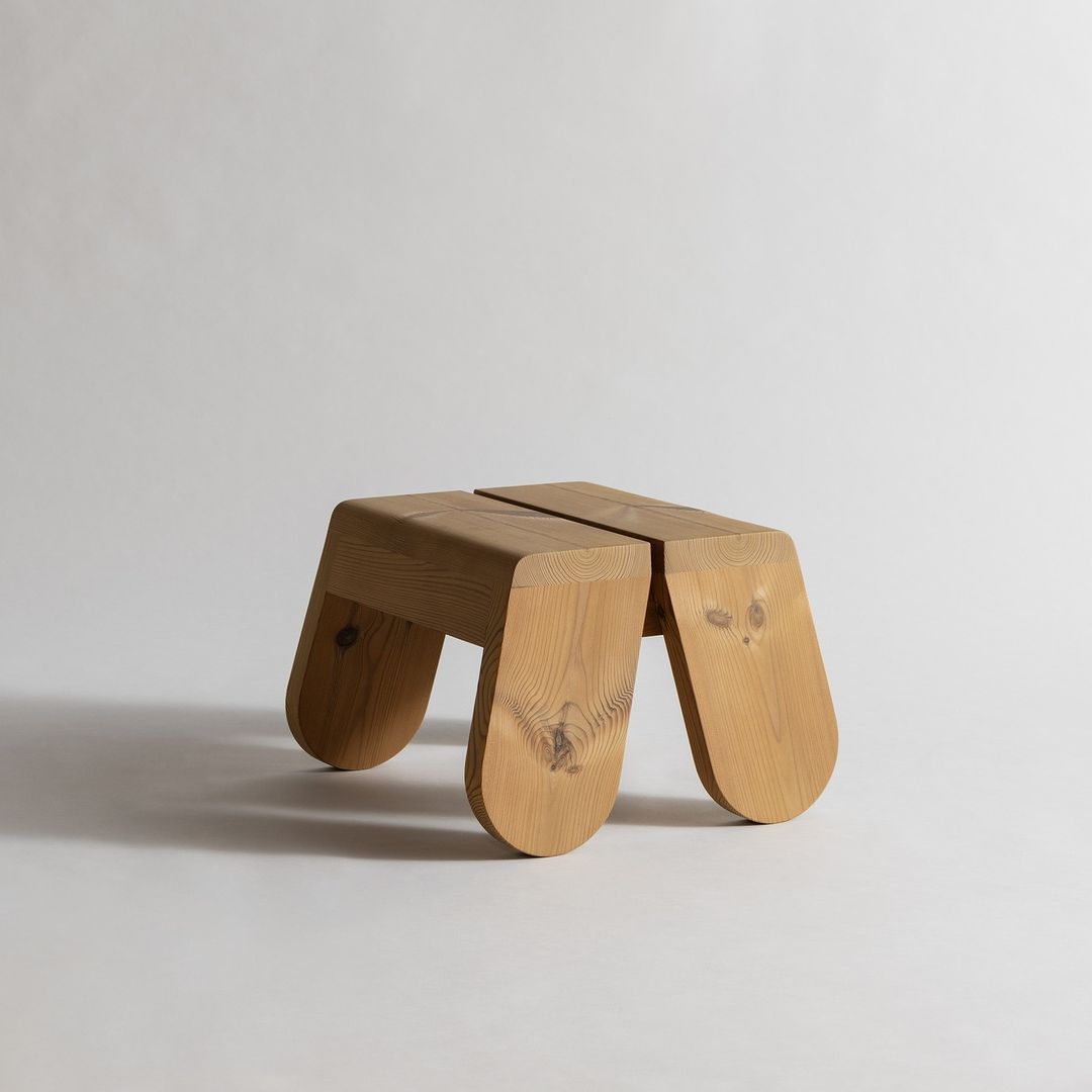 A uniquely crafted wooden stool with an organic, fluid form