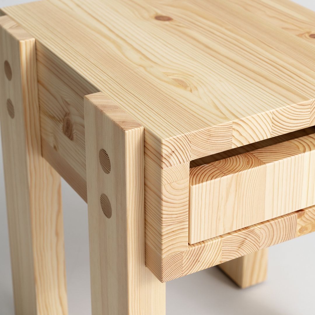 A sturdy pine table with visible joinery details and a sleek integrated drawer