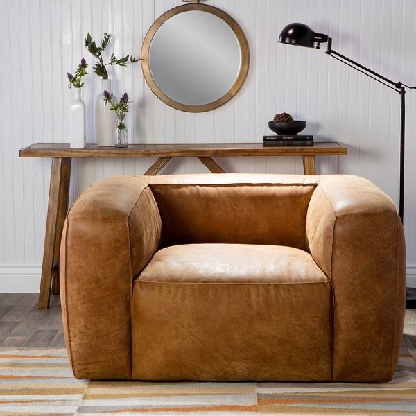 A chic, modern living room featuring a plush tan armchair