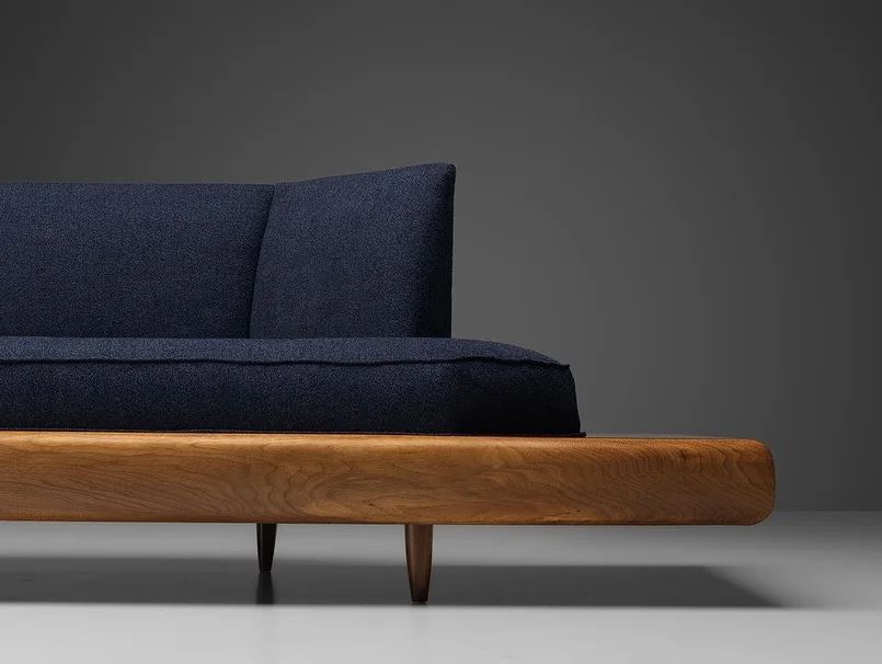 Stylish modern navy blue sofa with a solid wood base