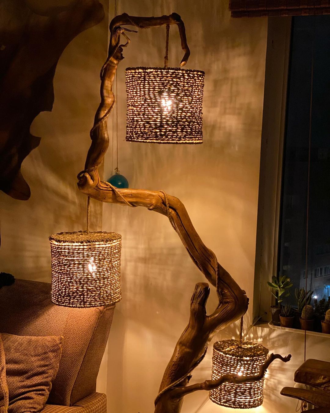 A rustic-style lighting fixture created from twisted branches and wicker lampshades