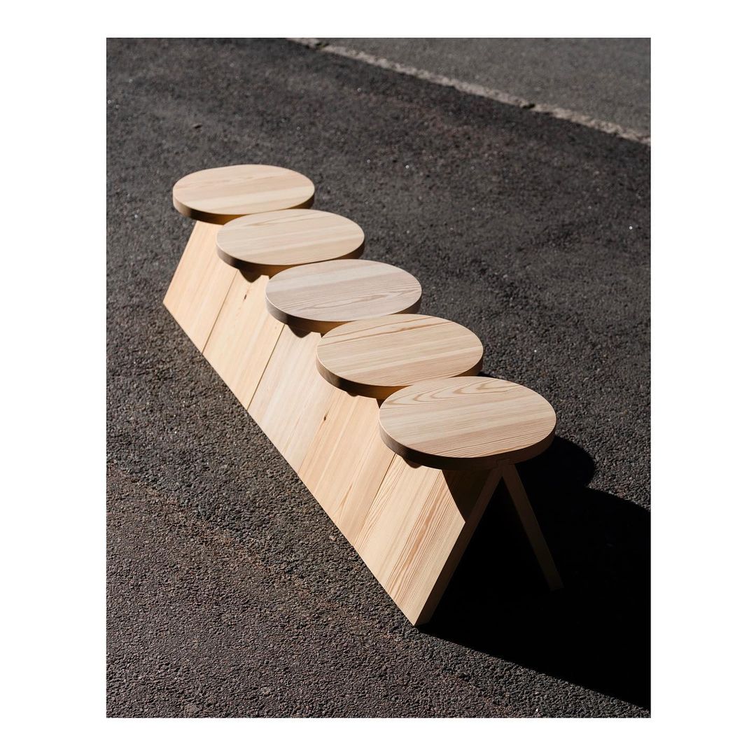 Unique wooden bench design creating a visual play on shadows on the ground