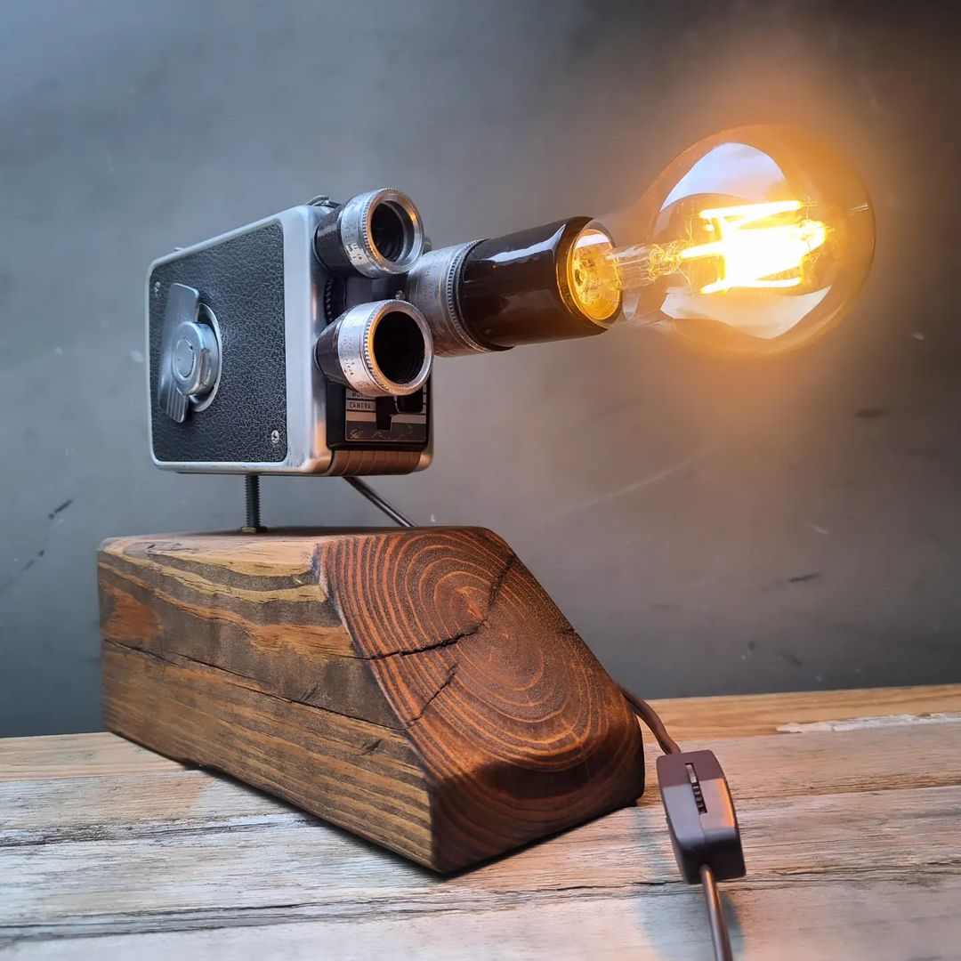 A unique lamp crafted from a vintage camera on a wooden stand