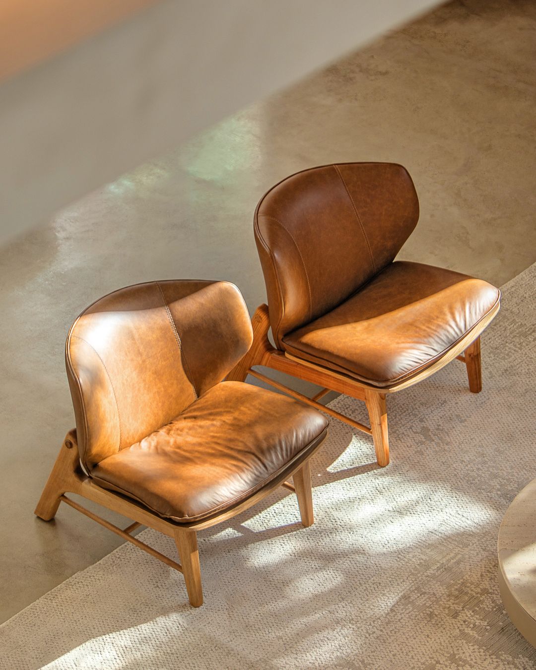 A pair of vintage style leather armchairs with mid-century modern design