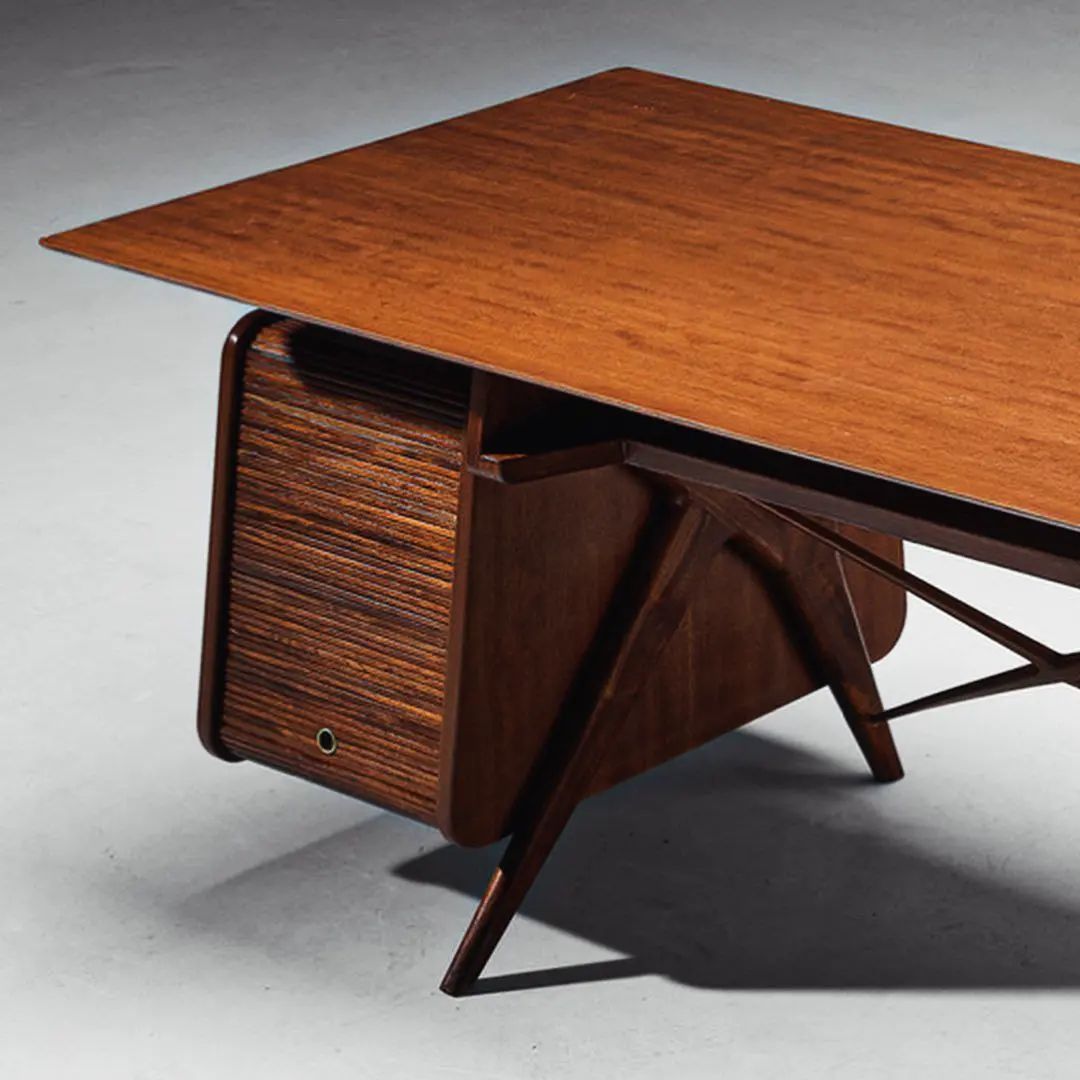 A vintage wooden table with a retractable side cabinet and slatted sliding doors.