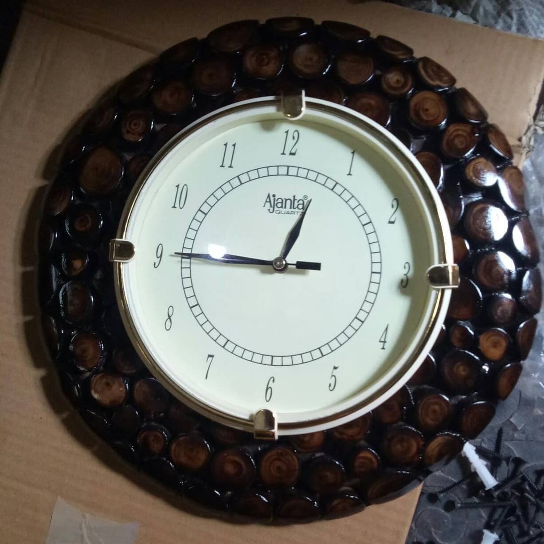 A uniquely designed wall clock surrounded by a frame of glossy chestnut-hued wooden slices