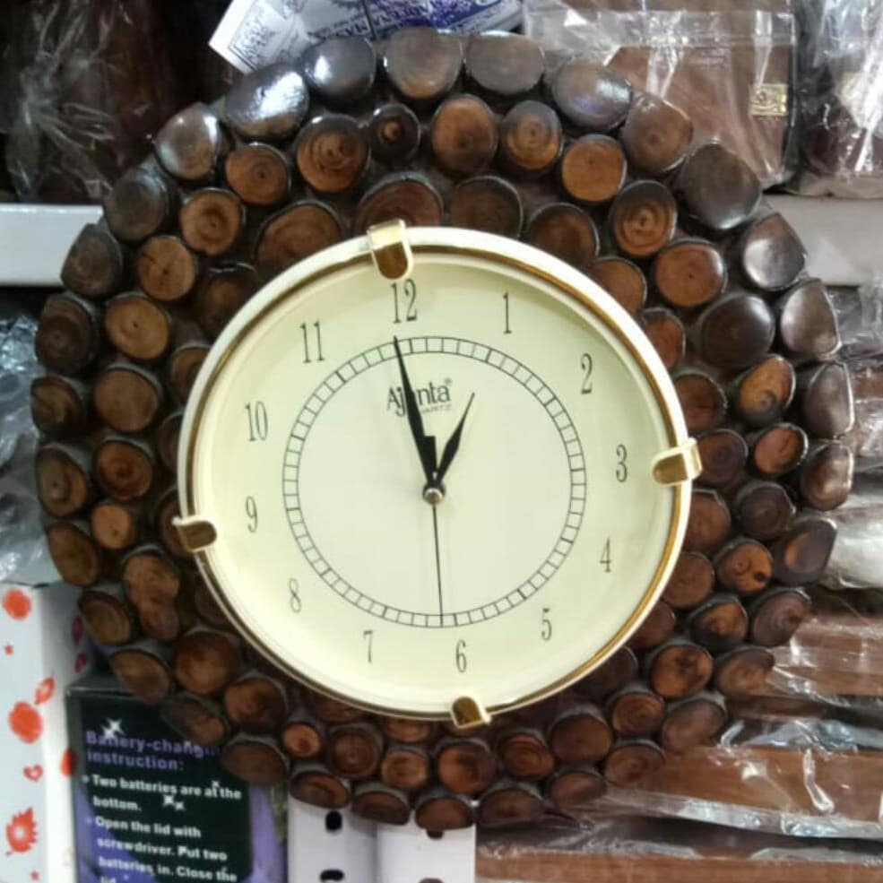 A uniquely designed wall arrangement featuring a classic analog clock surrounded by a pattern of organized, cylindrical wood slices