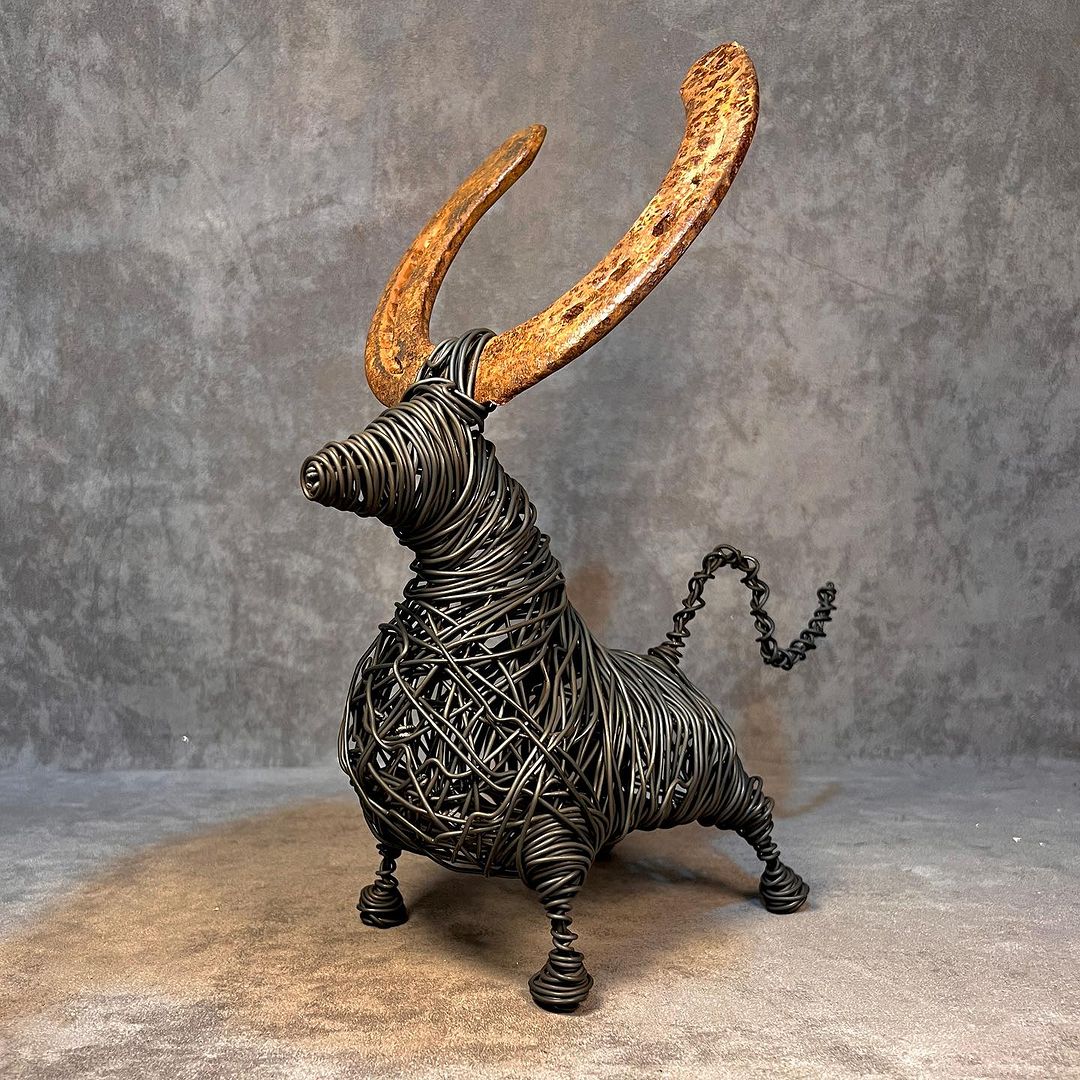 A whimsical wire and metal sculpture of a bull with rusted horns