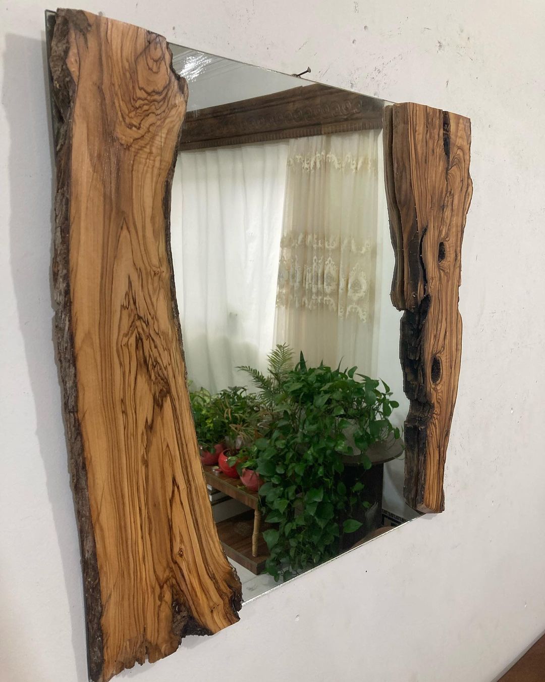 A rustic mirror framed with natural edged wooden planks